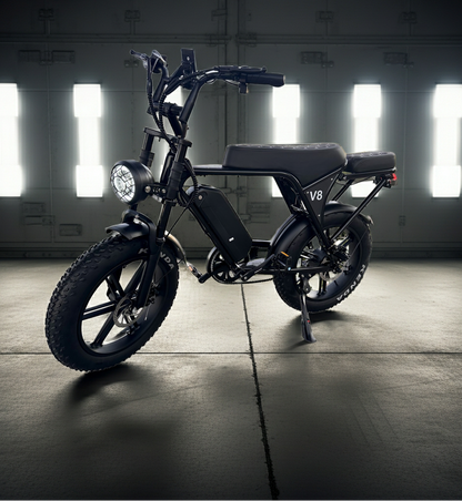 Black electric bike with 'V8' branding in a dimly lit warehouse.